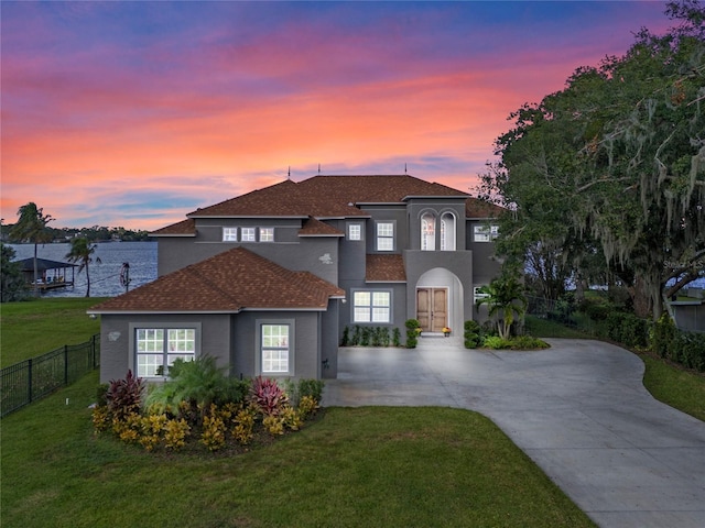 6019 Linneal Beach Dr, Apopka, FL 32703 - view of front of house with fence, roof with shingles, stucco siding, a yard, and driveway