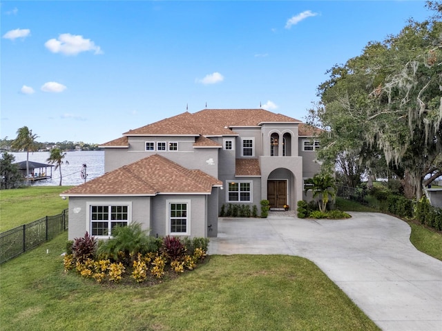 mediterranean / spanish-style home featuring a front yard and a water view