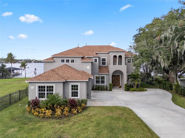 6019 Linneal Beach Dr, Apopka, FL 32703 - mediterranean / spanish-style house with fence, a front yard, stucco siding, a shingled roof, and concrete driveway