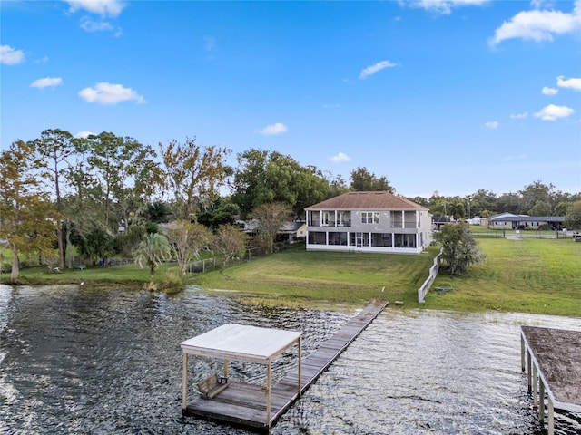 view of dock with a yard and a water view