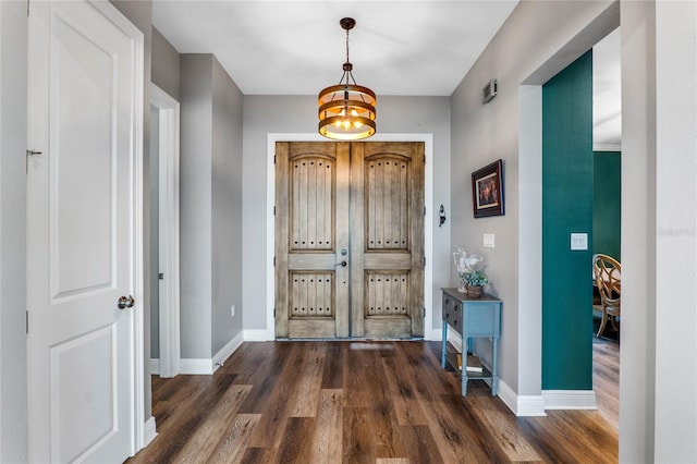 foyer entrance featuring a notable chandelier and dark hardwood / wood-style flooring