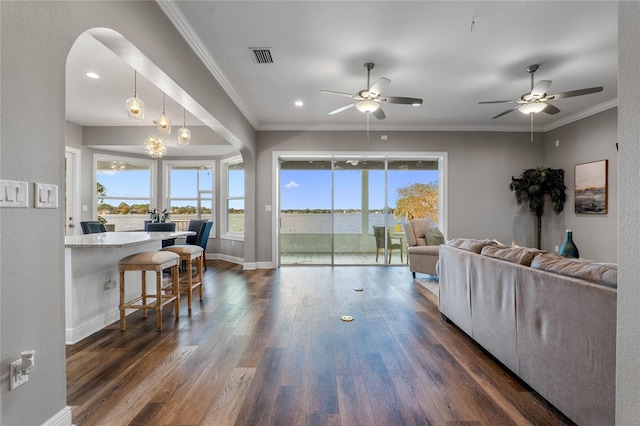 living room with crown molding, dark wood-type flooring, and ceiling fan