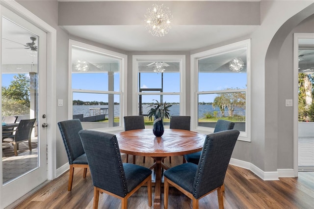 6019 Linneal Beach Dr, Apopka, FL 32703 - dining space featuring wood finished floors, baseboards, plenty of natural light, arched walkways, and ceiling fan with notable chandelier