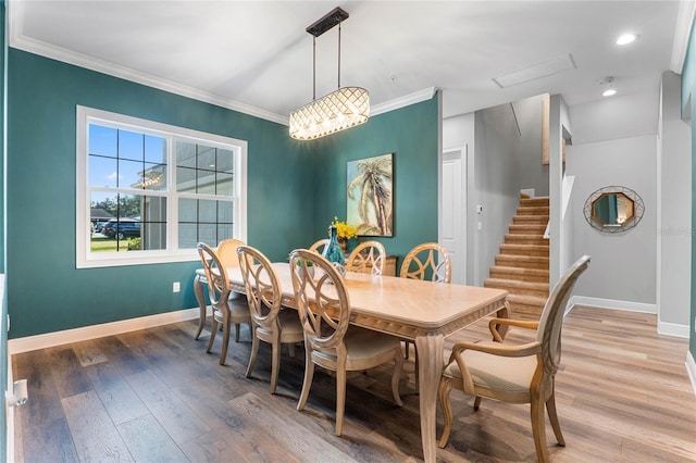 dining space with ornamental molding and hardwood / wood-style flooring