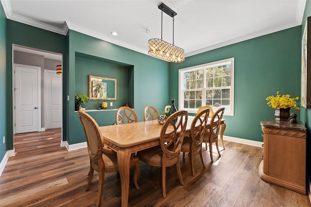 dining space with crown molding and dark hardwood / wood-style flooring