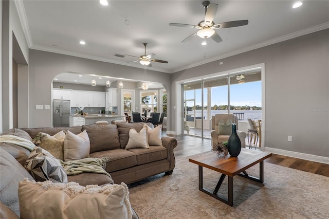 6019 Linneal Beach Dr, Apopka, FL 32703 - living area with crown molding, arched walkways, a ceiling fan, recessed lighting, and wood finished floors