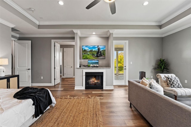 bedroom with access to outside, dark wood-type flooring, ornamental molding, a raised ceiling, and ceiling fan