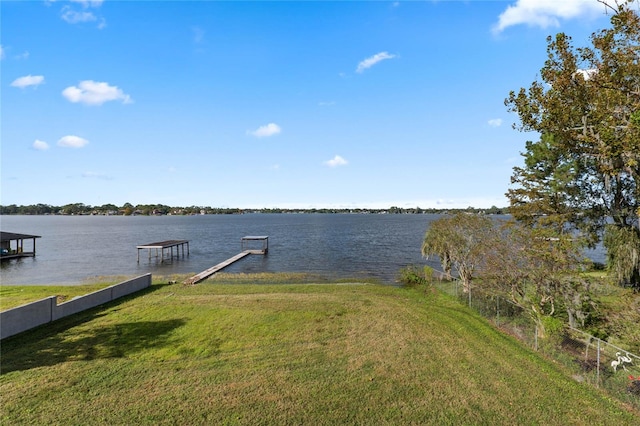 view of dock featuring a yard and a water view