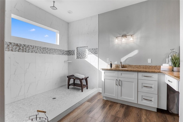 bathroom featuring vanity, wood-type flooring, and walk in shower