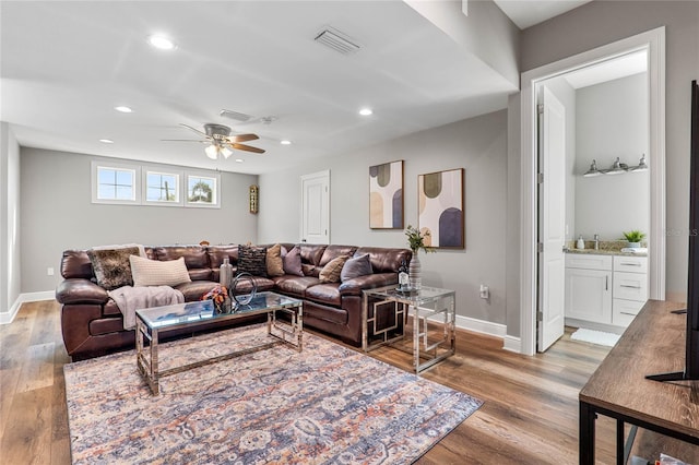 living room with sink, light hardwood / wood-style floors, and ceiling fan