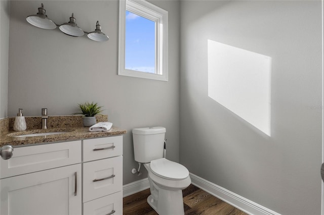 bathroom featuring toilet, hardwood / wood-style flooring, and vanity