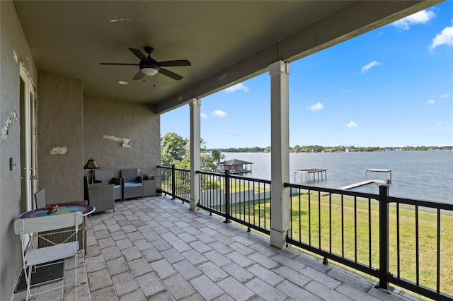 view of patio featuring a balcony, a water view, and ceiling fan