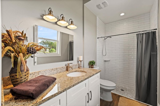 bathroom with vanity, toilet, hardwood / wood-style flooring, and walk in shower