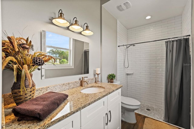 6019 Linneal Beach Dr, Apopka, FL 32703 - full bath with vanity, visible vents, wood finished floors, toilet, and a tile shower