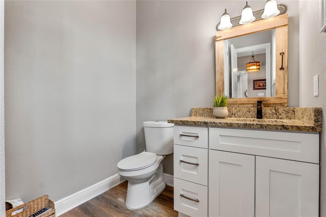 bathroom with vanity, toilet, and hardwood / wood-style flooring