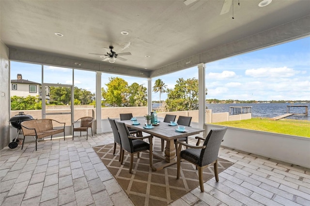 sunroom featuring a wealth of natural light, a water view, and ceiling fan