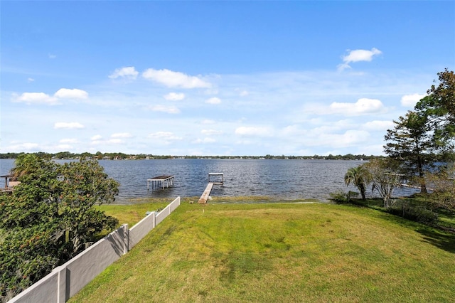 view of dock with a water view and a yard