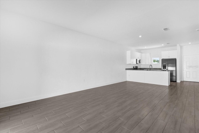 unfurnished living room with sink and dark hardwood / wood-style flooring