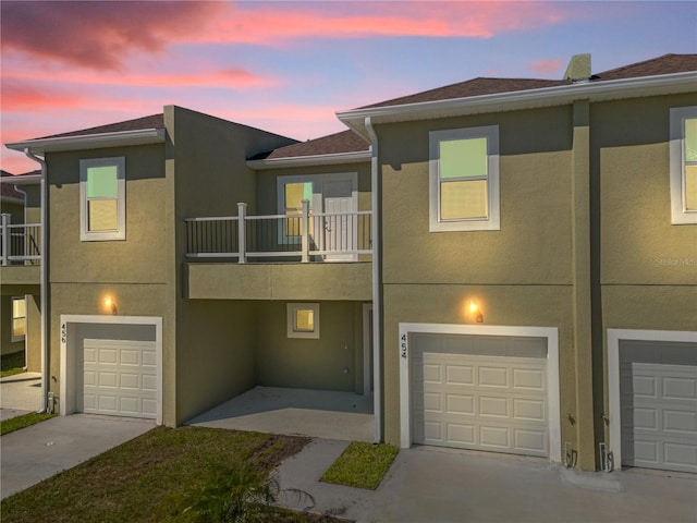 view of property with a balcony and a garage