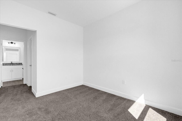 454 Lake Shore Pkwy, Davenport, FL 33896 - empty room with dark colored carpet, a sink, and baseboards