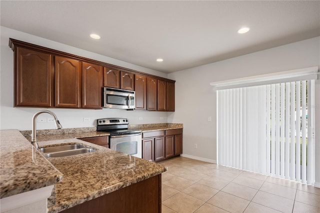 kitchen with light stone countertops, light tile patterned flooring, recessed lighting, a sink, and appliances with stainless steel finishes