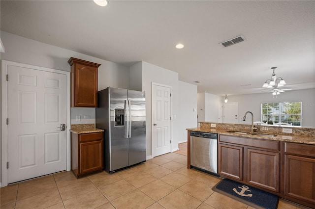 kitchen with visible vents, light stone counters, appliances with stainless steel finishes, light tile patterned flooring, and a sink