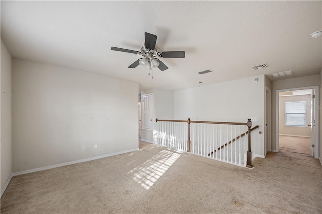 empty room with carpet flooring, baseboards, and visible vents