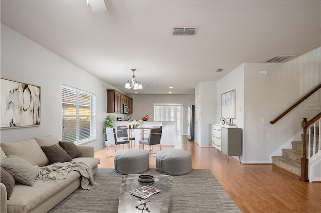 living room with light hardwood / wood-style flooring and a chandelier