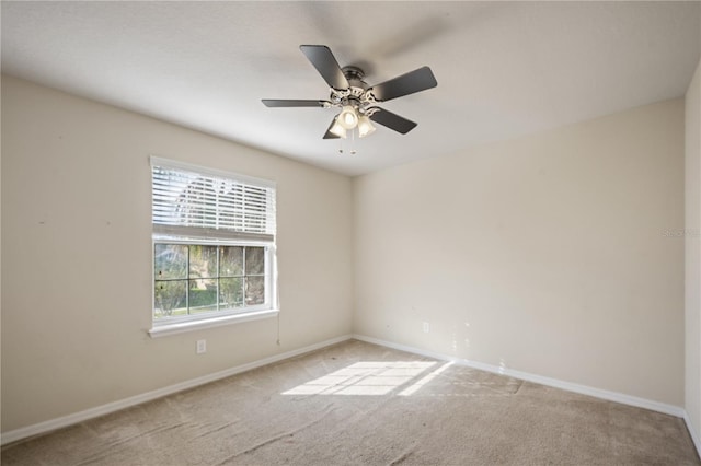 unfurnished room with carpet flooring, a ceiling fan, and baseboards