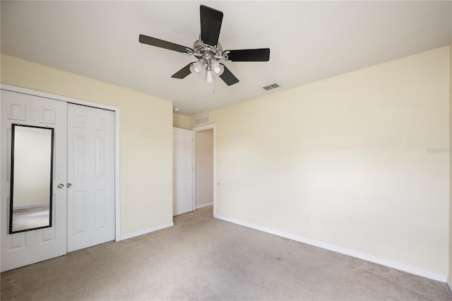 unfurnished bedroom with a ceiling fan, visible vents, baseboards, a closet, and light colored carpet