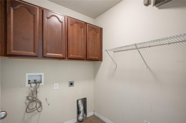 clothes washing area featuring electric dryer hookup, washer hookup, a textured ceiling, cabinet space, and baseboards