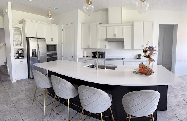 kitchen featuring a large island, white cabinets, stainless steel appliances, and a textured ceiling