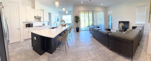 kitchen with sink, an island with sink, decorative light fixtures, and white cabinets