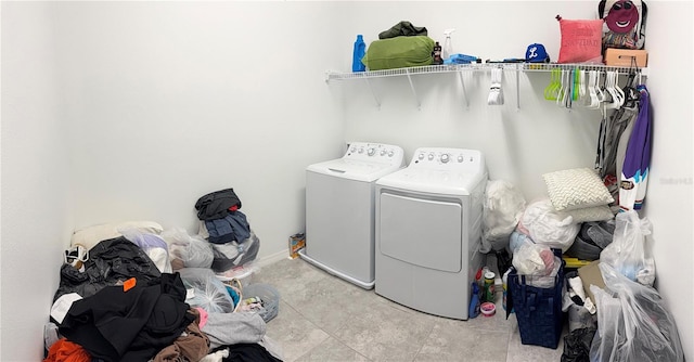 laundry area with washing machine and clothes dryer and light tile patterned floors