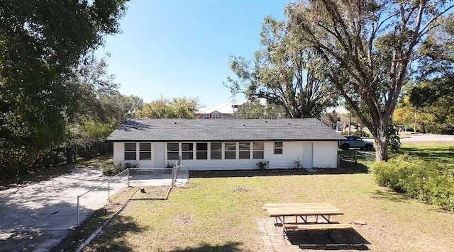 rear view of property featuring a lawn