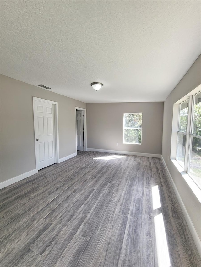 spare room with dark hardwood / wood-style floors and a textured ceiling