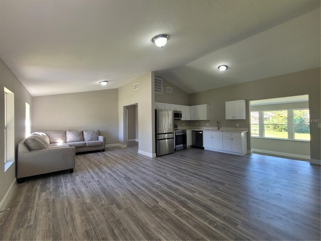 living room featuring a textured ceiling, sink, high vaulted ceiling, and dark hardwood / wood-style floors