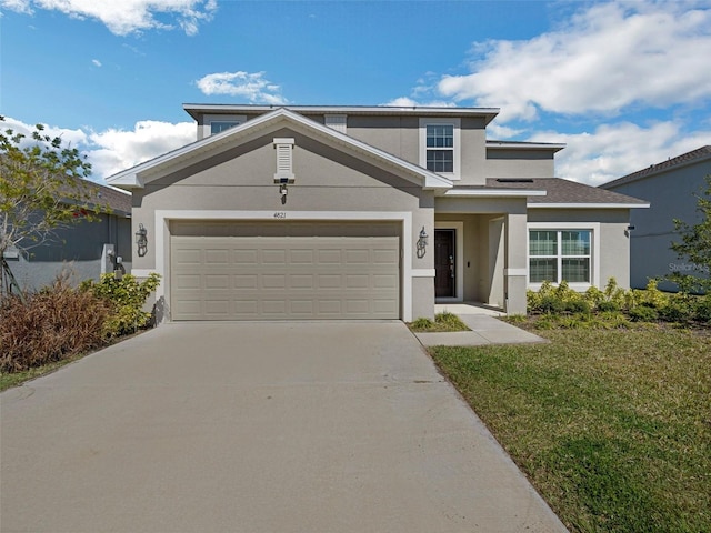 traditional-style house with driveway, a front lawn, and stucco siding