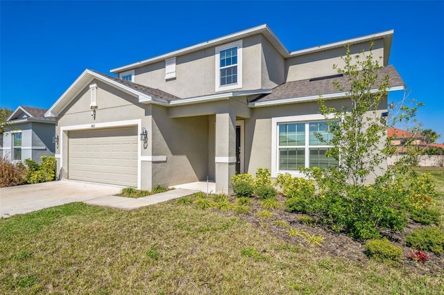 traditional-style house with a garage, driveway, a front yard, and stucco siding