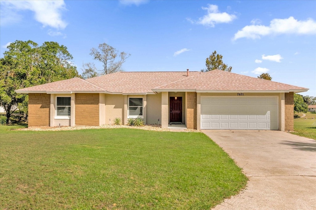 ranch-style home with a garage and a front lawn