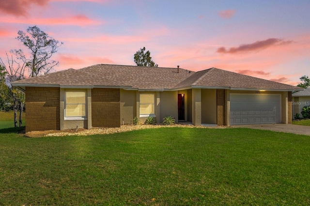 ranch-style home with a garage and a lawn