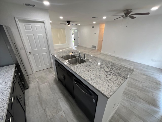 kitchen featuring black dishwasher, sink, light stone counters, and a kitchen island with sink