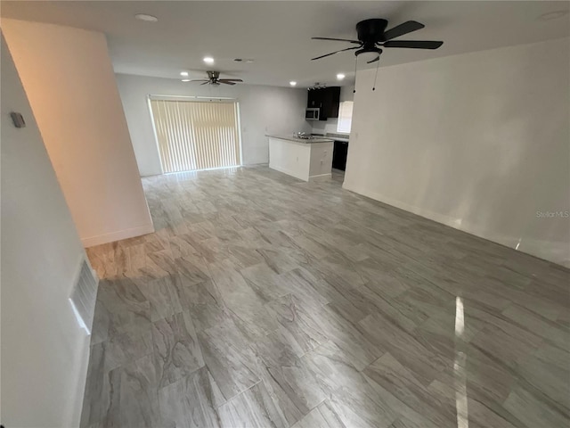 unfurnished living room with ceiling fan