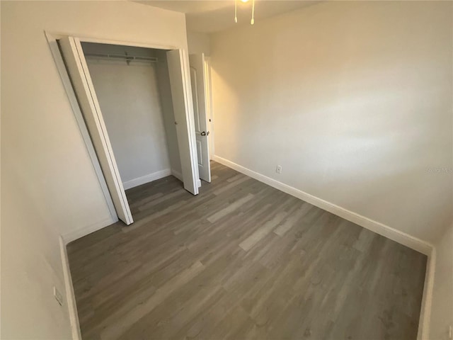 unfurnished bedroom featuring dark hardwood / wood-style floors and a closet