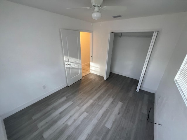 unfurnished bedroom featuring dark wood-type flooring, ceiling fan, and a closet