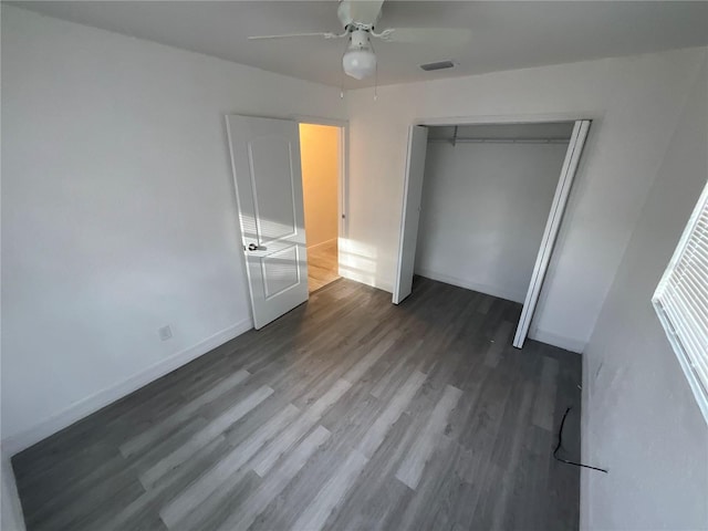 unfurnished bedroom with a closet, dark wood-type flooring, and ceiling fan