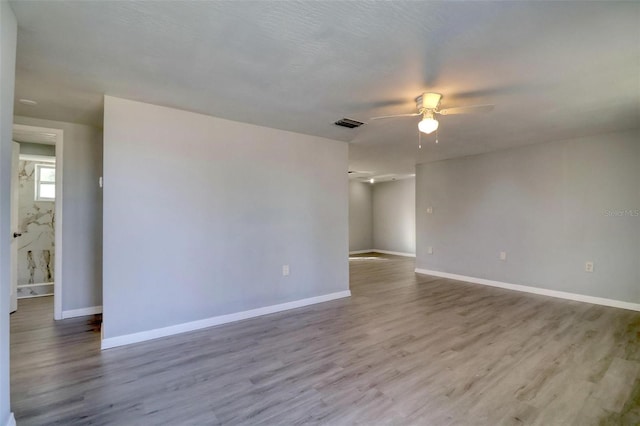 empty room with ceiling fan and light wood-type flooring