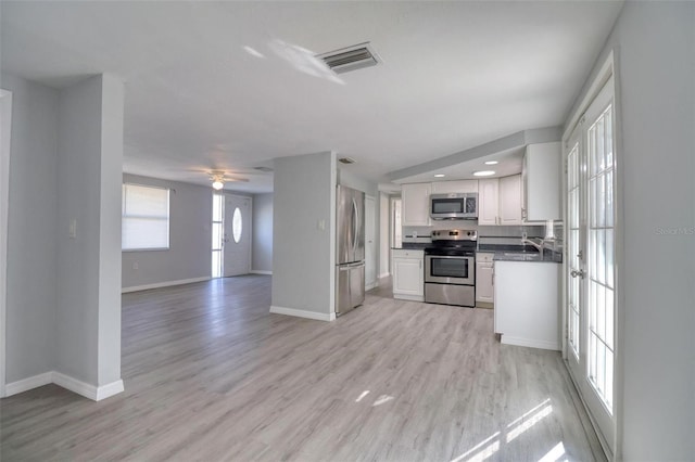 kitchen with ceiling fan, light wood-type flooring, white cabinetry, and appliances with stainless steel finishes