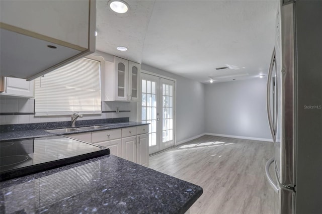 kitchen with stainless steel fridge, french doors, sink, light hardwood / wood-style flooring, and white cabinetry