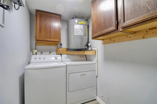 laundry area with washing machine and dryer, water heater, and cabinets